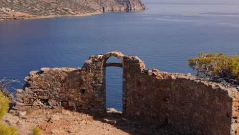 Die-Alten-Torbogen-Eingangsruinen-Blicken-Auf-Die-Atemberaubende-Blaue-Bucht-Auf-Der-Insel-Spinalogka-Auf-Kreta-In-Griechenland