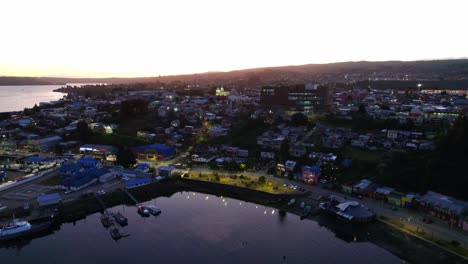 Paisaje-Aéreo-De-Viajes-Al-Atardecer-De-La-Isla-Castro-Patagonia-Chiloé,-Destino-Turístico-Chileno,-Horizonte-Y-Casas-Del-Delta-Alrededor-De-La-Romántica-Orilla-Del-Mar