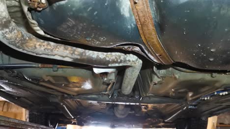 Rusted-undercarriage-of-car-lifted-up-for-inspection-in-service