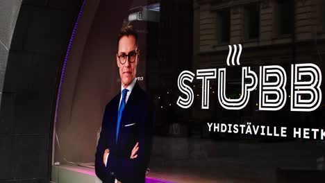 President-of-Finland-Alexander-Stubb-election-office-in-Helsinki-downtown,-man-in-suit,-confident-pose,-urban-setting,-late-evening,-dramatic-lighting,-billboard