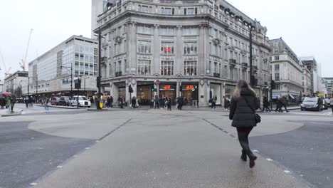 Daytime-view-of-busy-Oxford-Street-crosswalk-with-pedestrians-and-traffic,-cloudy-sky