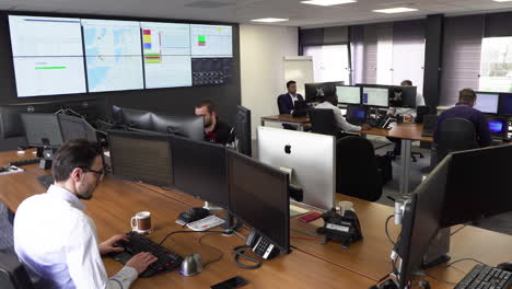 Inside-modern-finance-office-with-male-employees-working-hard-on-their-computers