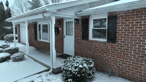 Casa-De-Ladrillo-De-Una-Sola-Planta-Cubierta-De-Nieve,-Con-Patio-Delantero-Y-árboles-Desnudos