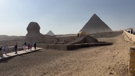 Esfinge-Y-Pirámides-Con-Turistas-Bajo-El-Cielo-Despejado,-Meseta-De-Giza