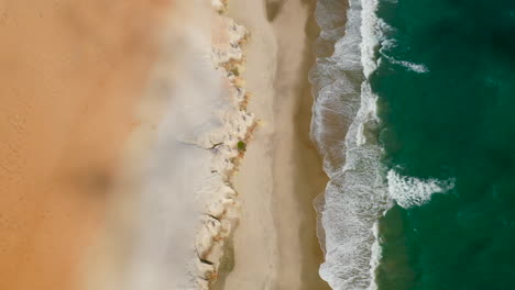 Aerial-view-of-the-sea,-waves-and-the-cliffs-of-Morro-Branco,-Ceara,-Brazil