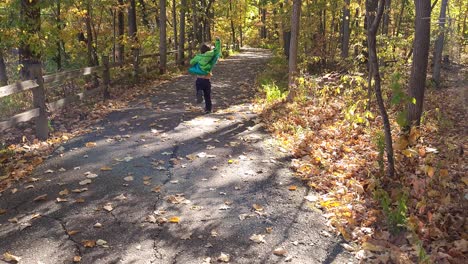 Young-boy-running-in-Oakwoods-Metropark,-Michigan,-USA