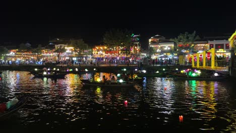 Hoi-An-Vietnam-Laternen-Und-Laternenboote-Entlang-Des-Thu-Bon-Flusses-Mit-Der-Goldenen-Brücke-Und-Dem-An-Hoi-Nachtmarkt-Im-Hintergrund