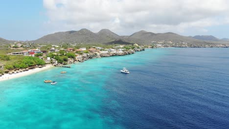 Playa-kalki-in-curacao-with-clear-turquoise-water-and-moored-boats,-aerial-view