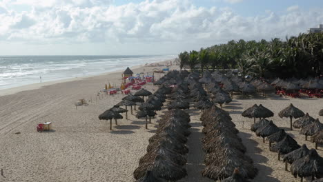 Vista-Aérea-De-La-Playa,-Con-Muchas-Sombrillas-Y-Palmeras,-Praia-Do-Futuro,-Ceará,-Brasil.