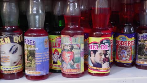 Pan-across-colorful-magic-potions-in-recycled-bottles,-Bolivia-store