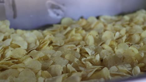 POV-Aufnahme-Aus-Nächster-Nähe,-Man-Sieht,-Wie-Die-Chips-Aus-Der-Maschine-Frittiert-Werden-Und-Auf-Das-Förderband-Gelangen-Und-Die-Verpackung-Verarbeitet-Wird