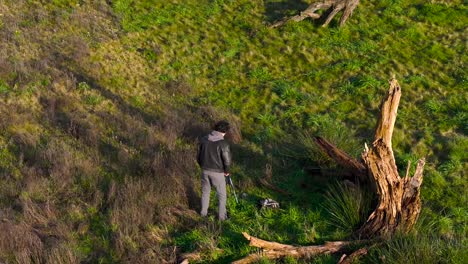 Outdoor-Photographer-Next-To-Dead-Tree-Wood-On-Rural-Landscape