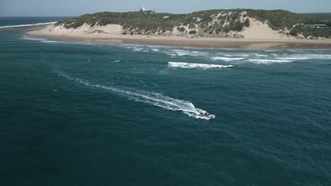 Aerial-shot-of-a-small-boat-sailing-through-choppy-sea-at-Mozambique