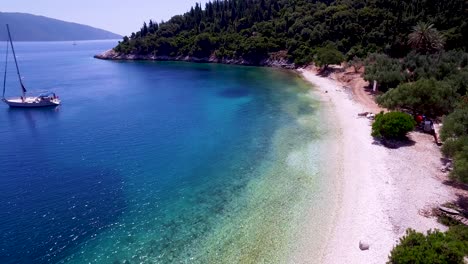 Aerial-shot-of-Foki-Beach-in-Kefalonia,-Greece-with-clear-turquoise-waters-and-lush-greenery