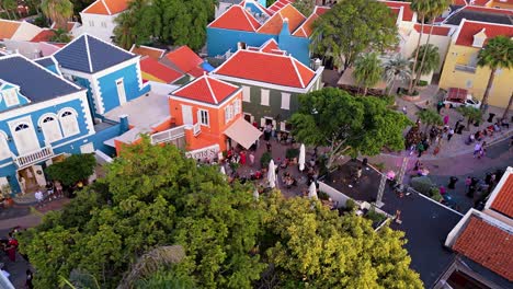 Drone-orbit-past-trees-to-reveal-vibrant-multicolored-home-buildings-of-Kura-Hulanda-village-in-Otrobanda-Willemstad-Curacao
