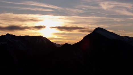 Silueta-Retroiluminada-De-Las-Montañas-De-Agrafa-Grecia-Mientras-El-Sol-Brilla-Intensamente-Frente-A-Tenues-Nubes