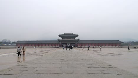 Gyeongbokgung-Palace-in-Seoul,-Korea-on-gray-rainy-winter-day-with-people