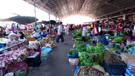 A-sweeping-panorama-of-Dao-Heuang-Public-Market-reveals-a-bustling-atmosphere-teeming-with-activity,-as-vendors-showcase-their-goods-and-shoppers-navigate-through-the-lively-scene