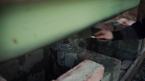 The-Man-is-Employing-Cement-to-Anchor-the-Bricks-Beneath-the-Self-made-Hot-Tub---Close-Up