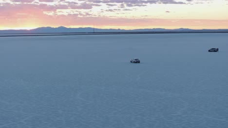Vehicle-and-people-in-Bonneville-Salt-Flats-at-sunset,-Utah