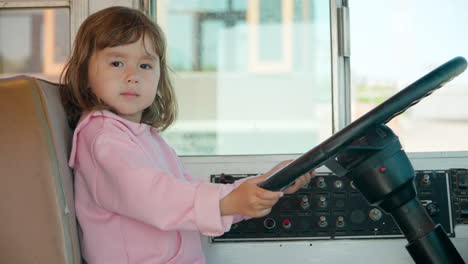 Una-Niña-De-3-Años-Sentada-En-El-Asiento-Del-Conductor-Finge-Conducir-Un-Autobús-Antiguo-De-Verdad