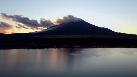 Silueta-Del-Monte-Fuji-Al-Atardecer,-Reflexionando-Sobre-Un-Lago-Tranquilo-Con-Nubes