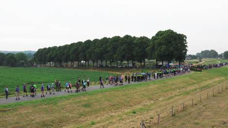 Long-line-of-walkers-during-the-Four-Days-Marches-Nijmegen,-Dutch,-aerial-shot,-rising