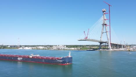 Frachtschiff-Fährt-Unter-Der-Gordie-Howe-International-Bridge-Hindurch,-Die-über-Den-Detroit-River-Gebaut-Wird,-Luftaufnahme