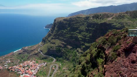 Vista-Aérea-Lateral-Del-Mirador-De-Abrante,-Paisaje-Rocoso-Rojo,-Costa-Verde-Al-Fondo,-Isla-De-La-Gomera