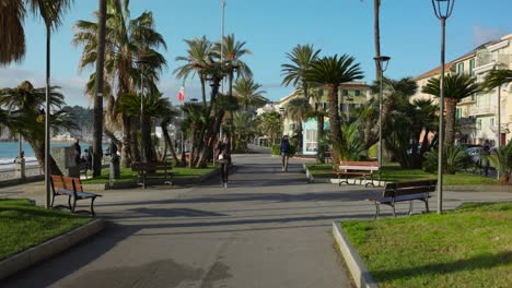 Seaside-promenade-in-Varazze,-Italy,-people-walking-on-sunny-day,-Italian-Riviera