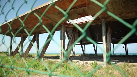 giant-dilapidated-concrete-monster-on-the-seashore-from-behind-the-fence