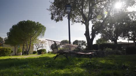 Foto-Panorámica-De-Un-Banco-En-Un-Parque-Con-La-Luz-Del-Sol-Saliendo-De-Los-árboles