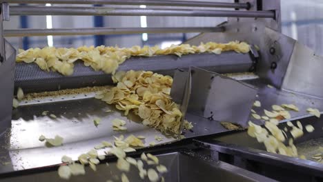 pov-shot-Chips-from-the-machine-are-fried-and-fall-onto-the-conver
