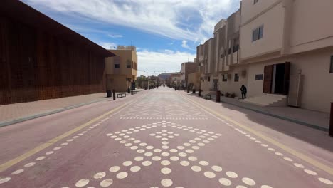 Al-Ula,-Saudi-Arabia---February-18-2024:-POV:-Old-town-street-with-no-cars,-cafes-and-restaurants-with-a-vibrant-cultural-center