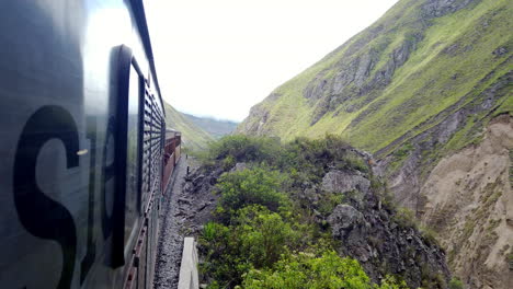 Train-journey-through-the-lush-green-Alausi-mountains-of-Ecuador,-cloudy-skies-overhead,-dynamic-side-view