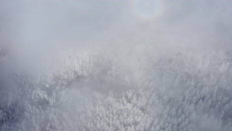 Toma-Aérea-De-Las-Montañas-Bucegi-Cubiertas-De-Nieve-Con-El-Fenómeno-De-La-Gloria-Brumosa