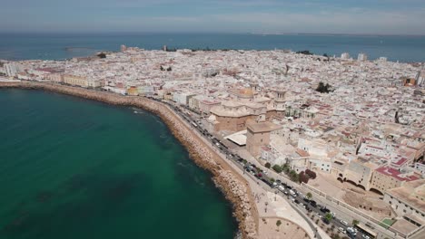 aerial-tilt-up-footage-of-ancient-Cadiz-cathedral-with-view-of-coastal-zone-and-old-town,-Cadiz-Spain
