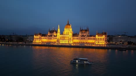 Paseo-En-Barco-Por-El-Río-Danubio-A-Lo-Largo-Del-Edificio-Del-Parlamento-En-Budapest,-Hungría---Antena-4k