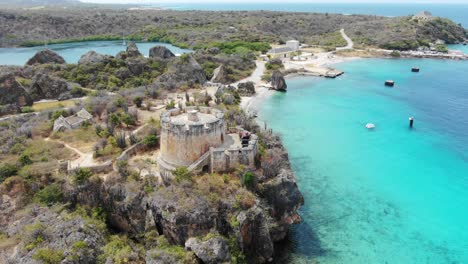 Tugboat-beach-in-curacao-with-clear-turquoise-waters-and-rocky-coastline,-aerial-view