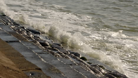 Plano-Medio-De-Olas-Rompiendo-Contra-Las-Defensas-Marítimas-En-Milford-On-Sea.