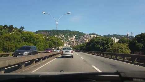 Fahren-Auf-Der-Straße-In-Rio-De-Janeiro-Mit-Überblick-über-Die-Favela-Am-Hang