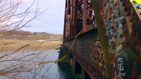 Aufnahmen-Von-Der-Seite-Einer-Alten-Eisenbahnbrücke-über-Einen-Fluss-In-Einer-Industriestadt