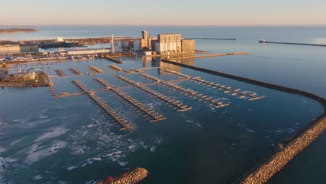 Port-colborne's-industrial-waterfront-and-marina-at-sunset,-calm-water,-aerial-view