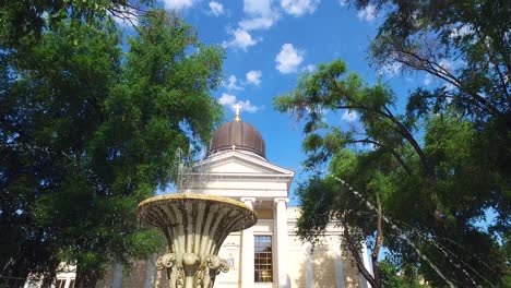 Wasserbrunnen-Mit-Der-Kathedrale-Von-Odessa,-Die-Zwischen-Den-Bäumen-Lauert