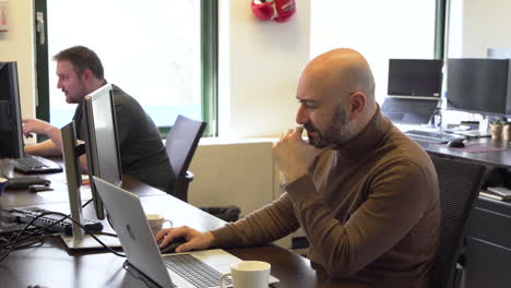 Trabajador-De-Oficina-Masculino-Centrado-En-Su-Computadora-Portátil-Durante-Las-Horas-De-Trabajo,-Toma-Estática