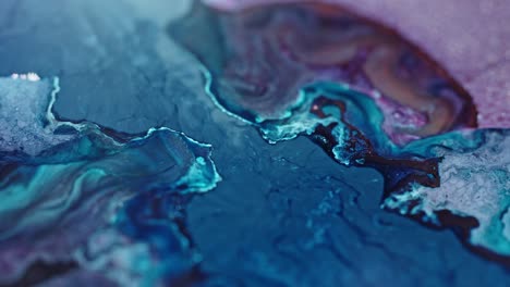 Close-up-of-vibrant-blue-and-pink-inks-diffusing-in-water,-creating-an-abstract,-fluid-art-pattern