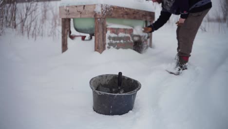 A-Man-is-Clearing-the-Snow-from-the-Bricks-Beneath-the-DIY-Hot-Tub---Static-Shot