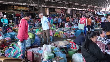 You-observe-a-bustling-public-market-in-Laos,-teeming-with-farmers,-vendors,-merchants,-distributors,-customers,-and-shoppers-located-in-Pakse,-Laos-called-Dao-Heuang-Morning-market