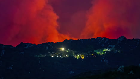 Panoramic-Landscape-of-a-wildfire-near-city-lights,-red-skyline,-smoke-burning,-environmental-disaster,-fire-blowing-near-valley-village