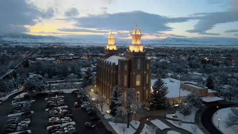 Aerial-orbit-establishing-view-of-entrance-to-Logan-Utah-LDS-temple-at-dusk-with-bright-lights